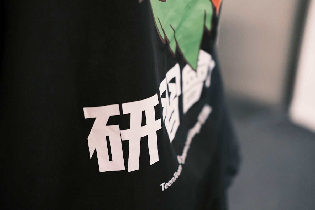 a person wearing a black t - shirt with a dragon on it