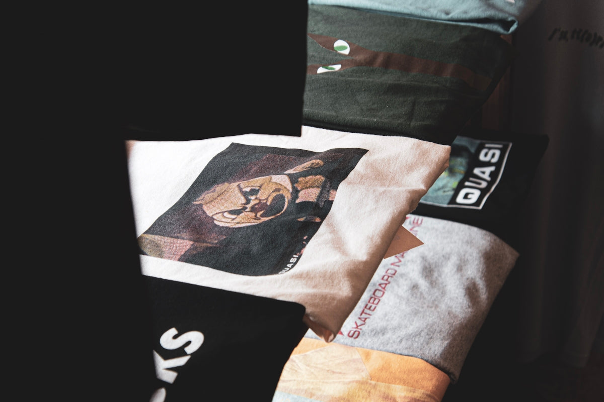 a pile of shirts sitting on top of a bed