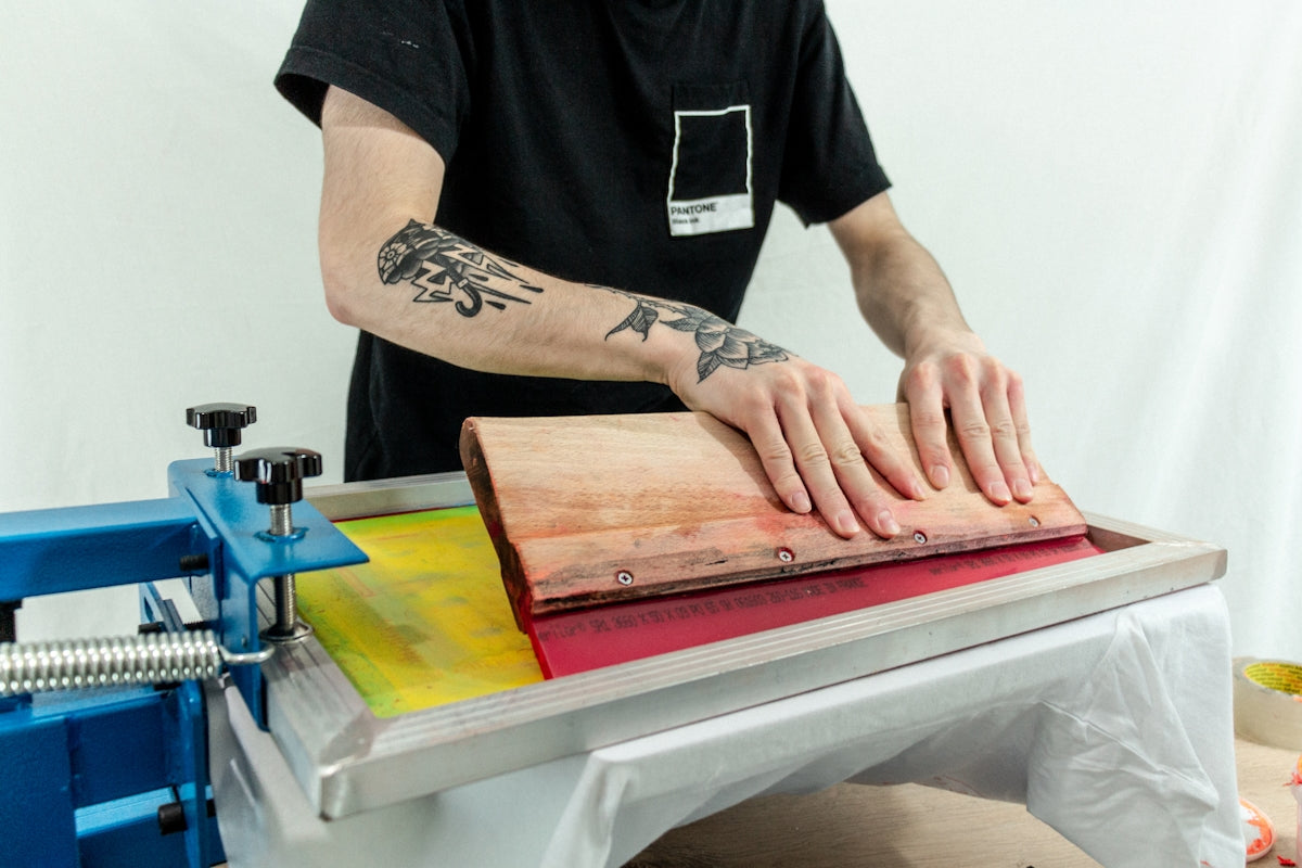 man in black crew neck t-shirt holding brown wooden chopping board