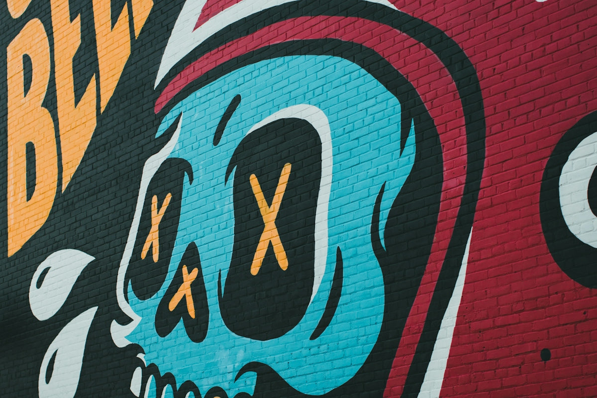 a colorful brick wall with a skull painted on it