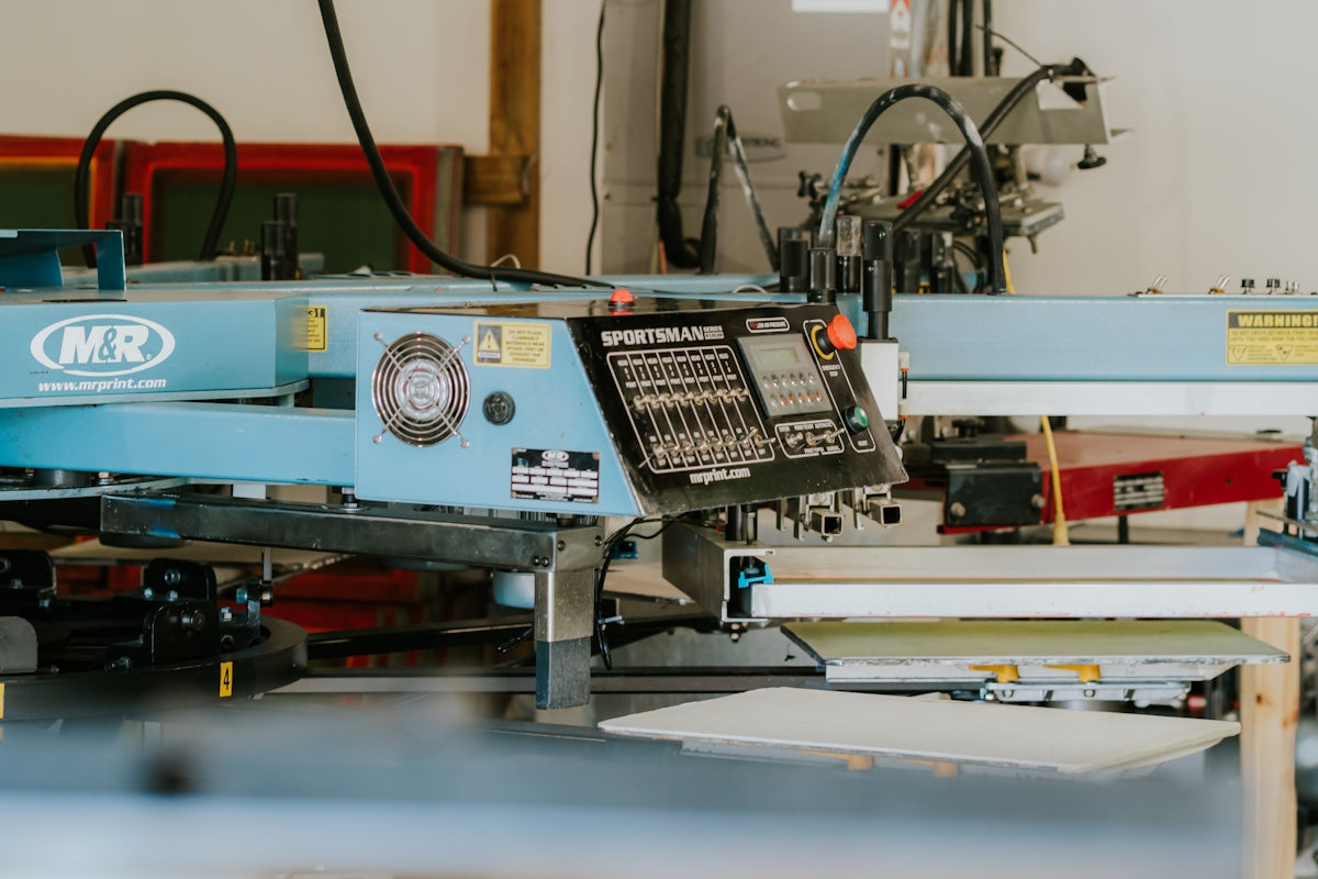 Industrial screen printing machine in a workshop setting.